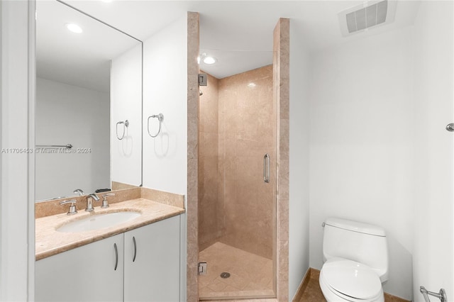 bathroom featuring vanity, toilet, and a shower with door