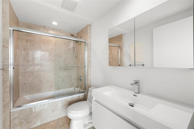 full bathroom featuring tile patterned floors, vanity, toilet, and shower / bath combination with glass door