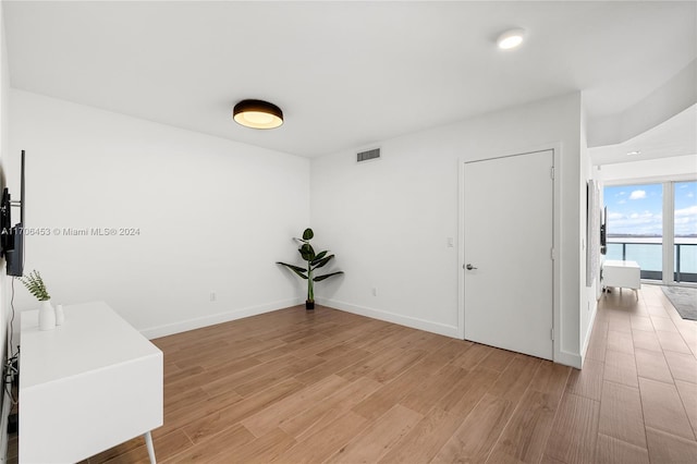 interior space with a water view and light wood-type flooring