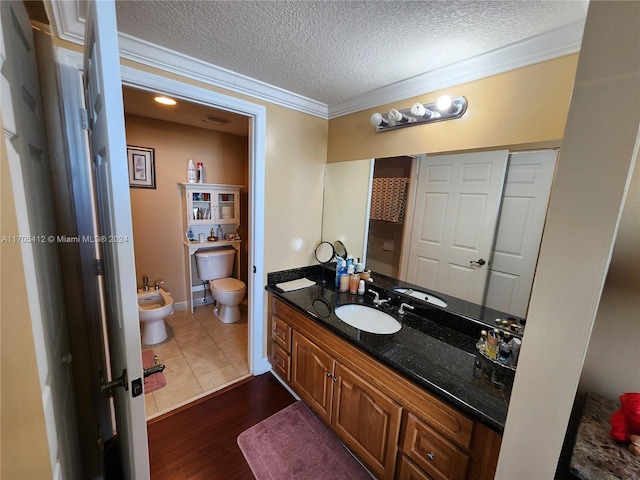 bathroom with vanity, a textured ceiling, crown molding, a bidet, and hardwood / wood-style floors