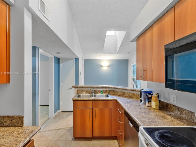 kitchen featuring a skylight, stainless steel dishwasher, white range oven, a textured ceiling, and light tile patterned floors