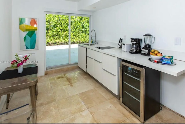 kitchen featuring white cabinetry, sink, and beverage cooler