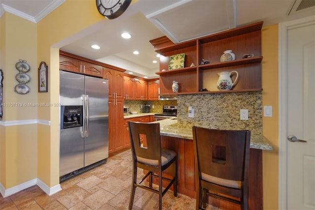 kitchen featuring kitchen peninsula, backsplash, light stone counters, stainless steel appliances, and a breakfast bar area