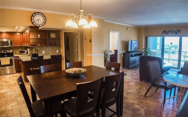 dining room featuring sink, crown molding, and a chandelier