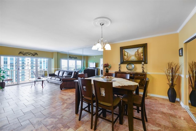 dining space with crown molding and a notable chandelier