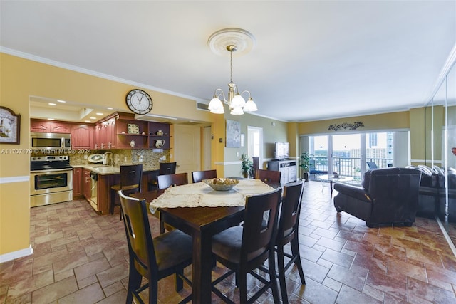 dining space with sink, a chandelier, and ornamental molding