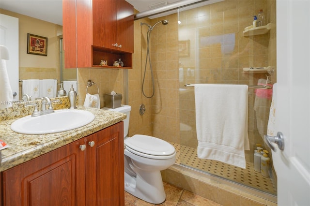 bathroom featuring a shower with door, vanity, and toilet