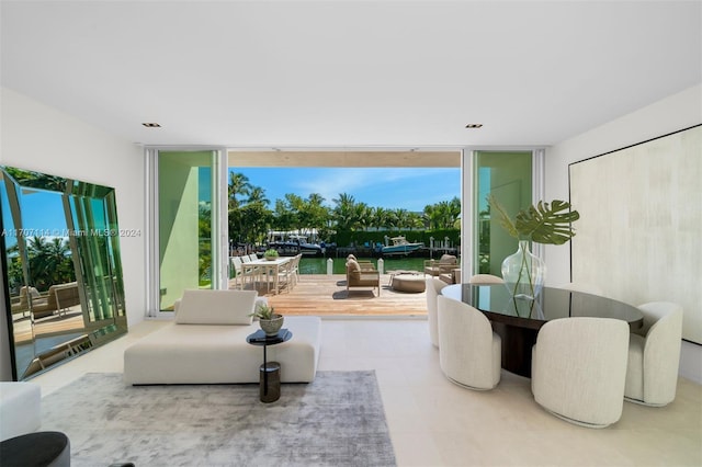 living room with tile patterned flooring, a water view, and floor to ceiling windows