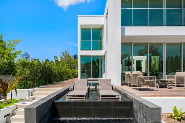 back of house with an outdoor living space and a patio