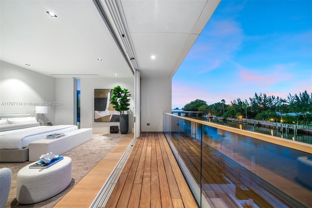 balcony at dusk with a water view and central air condition unit