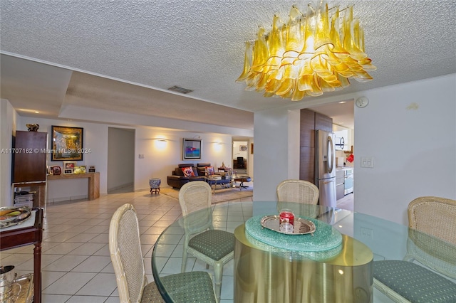 dining room featuring tile patterned floors, a textured ceiling, and an inviting chandelier