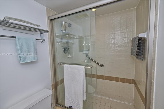 bathroom with toilet and a shower with door