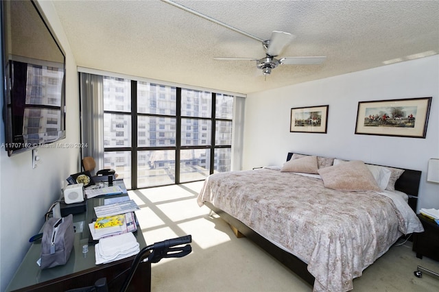 carpeted bedroom with a textured ceiling, floor to ceiling windows, and ceiling fan