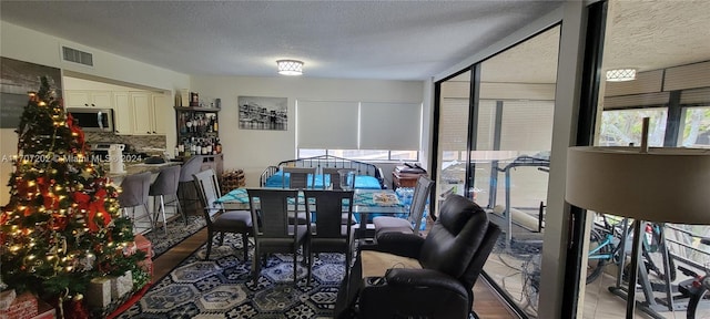 dining space with light hardwood / wood-style floors and a textured ceiling