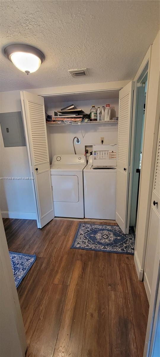 laundry area featuring dark hardwood / wood-style flooring, separate washer and dryer, a textured ceiling, and electric panel