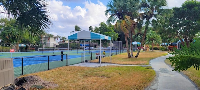 view of tennis court featuring a yard