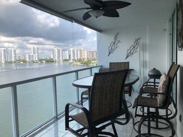 balcony featuring ceiling fan and a water view