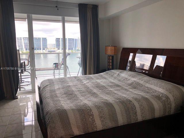 tiled bedroom featuring access to exterior and a water view