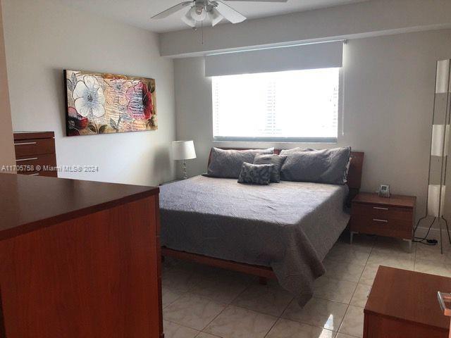 tiled bedroom with ceiling fan