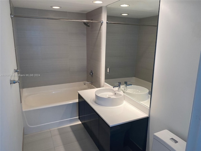 full bathroom featuring tile patterned flooring, vanity, toilet, and tiled shower / bath