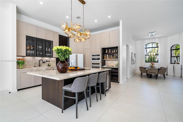 kitchen featuring a center island, decorative backsplash, white appliances, hanging light fixtures, and light stone countertops