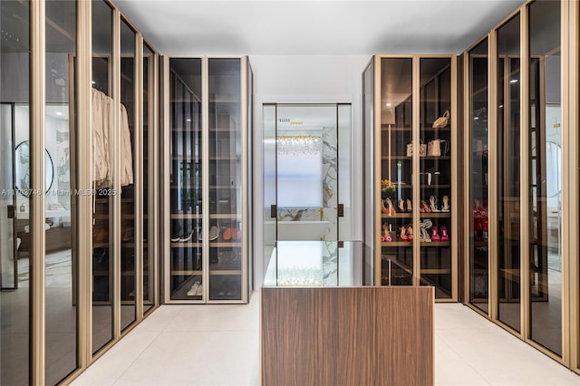 walk in closet with light tile patterned floors