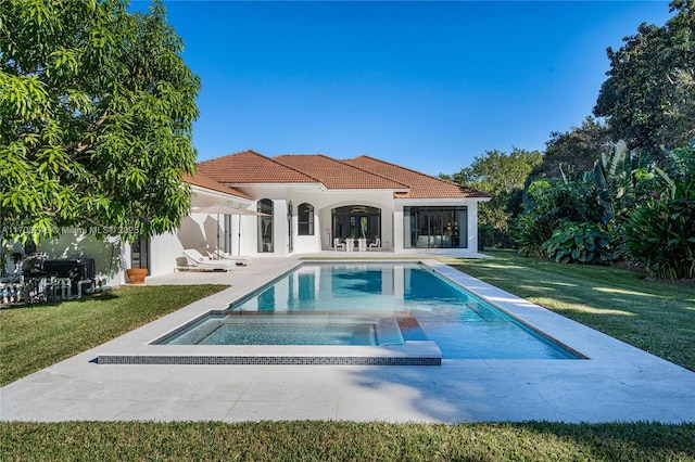 view of pool featuring an in ground hot tub, an outbuilding, a yard, and a patio