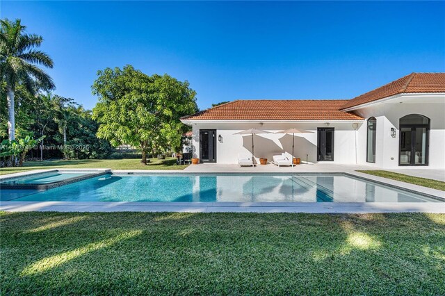 view of swimming pool with a lawn, a patio area, and an in ground hot tub