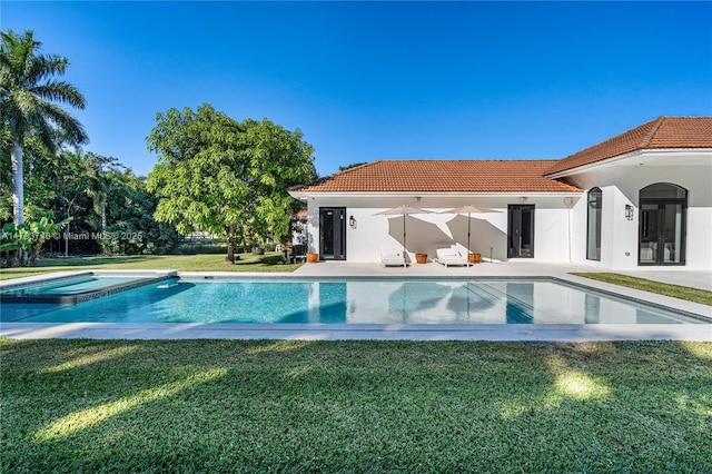 view of pool with a lawn, a patio, and an in ground hot tub