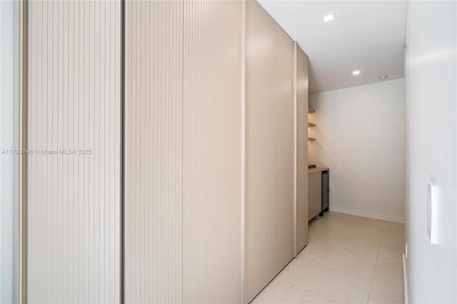 hall with light tile patterned floors