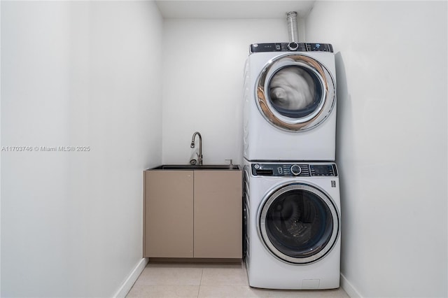 washroom featuring stacked washing maching and dryer, cabinets, light tile patterned flooring, and sink