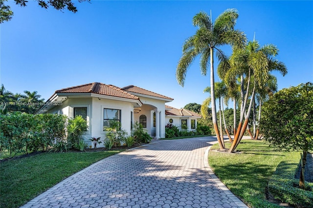 mediterranean / spanish house with a front lawn