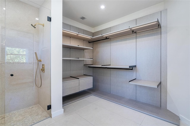 bathroom featuring a tile shower and tile patterned flooring