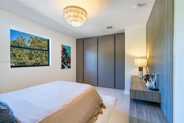 bedroom featuring an inviting chandelier and a closet