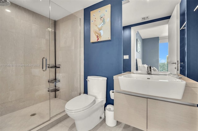 bathroom featuring tile patterned floors, vanity, toilet, and a shower with shower door