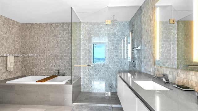 bathroom featuring vanity, backsplash, tile patterned floors, separate shower and tub, and tile walls