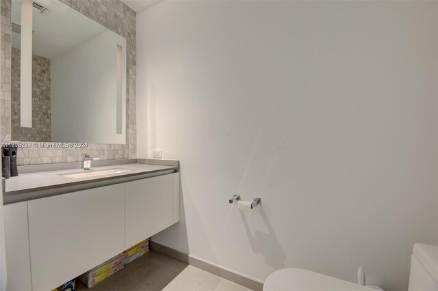 bathroom with tasteful backsplash, vanity, and toilet