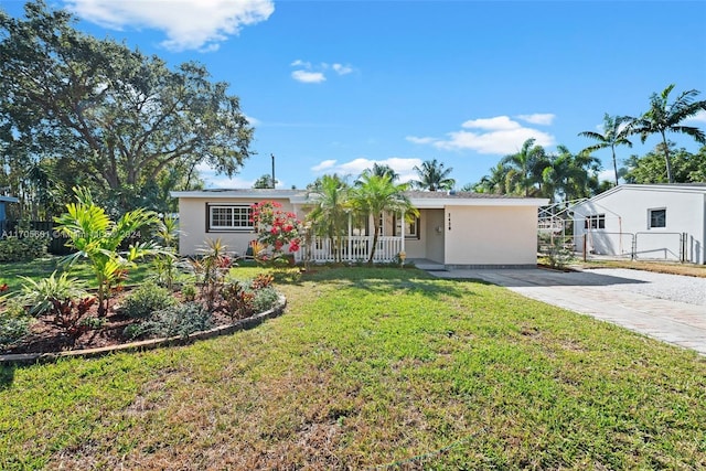 single story home featuring covered porch and a front yard