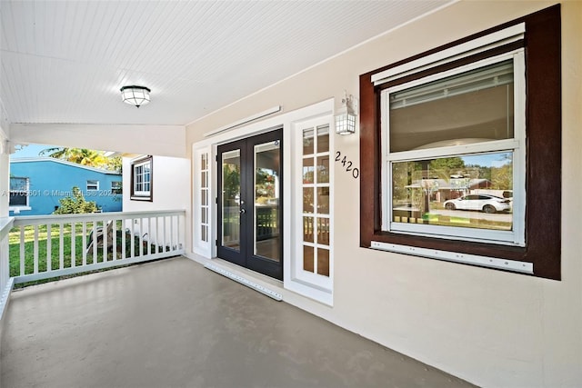 balcony featuring covered porch and french doors