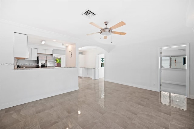 unfurnished living room featuring ceiling fan and crown molding