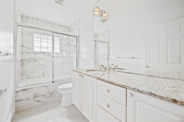 full bathroom with shower / bath combination with glass door, vanity, toilet, and tile patterned flooring