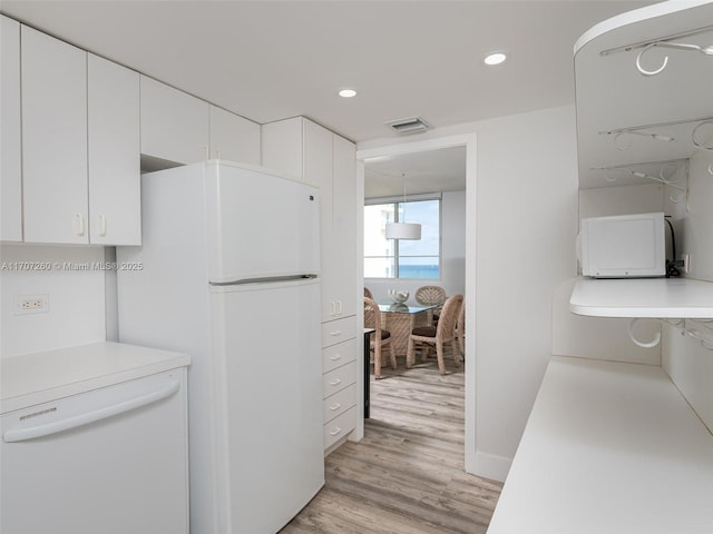 kitchen with white cabinetry, white appliances, and light hardwood / wood-style flooring