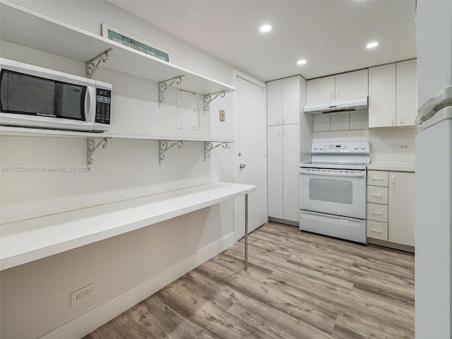 kitchen with white appliances, light hardwood / wood-style flooring, and white cabinets