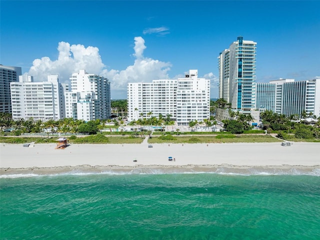 birds eye view of property with a water view and a beach view