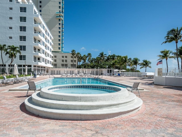 view of pool featuring a hot tub and a patio