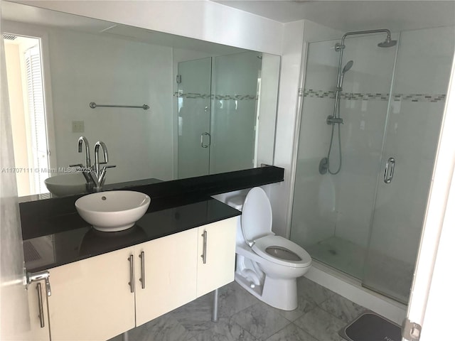 bathroom with vanity, a shower with door, and toilet