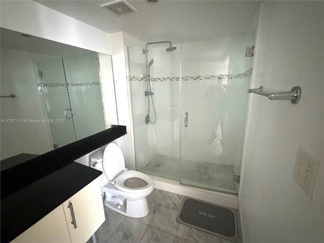 bathroom with vanity, tile patterned floors, a shower with door, and toilet