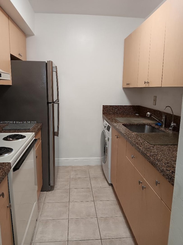 kitchen featuring light tile patterned flooring, sink, dark stone countertops, white electric stove, and washer / clothes dryer