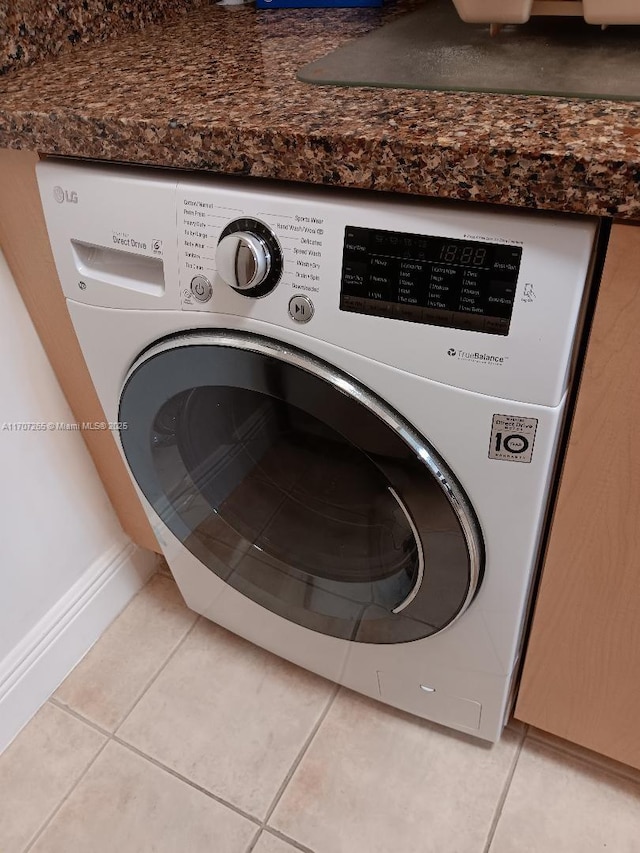 washroom with washer / dryer and light tile patterned flooring