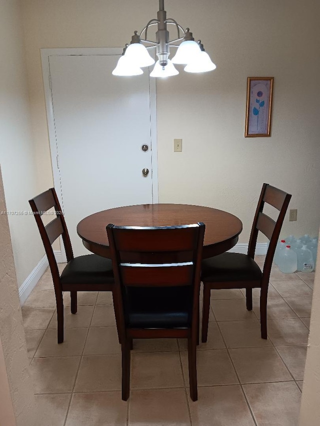 dining room featuring tile patterned flooring and a notable chandelier